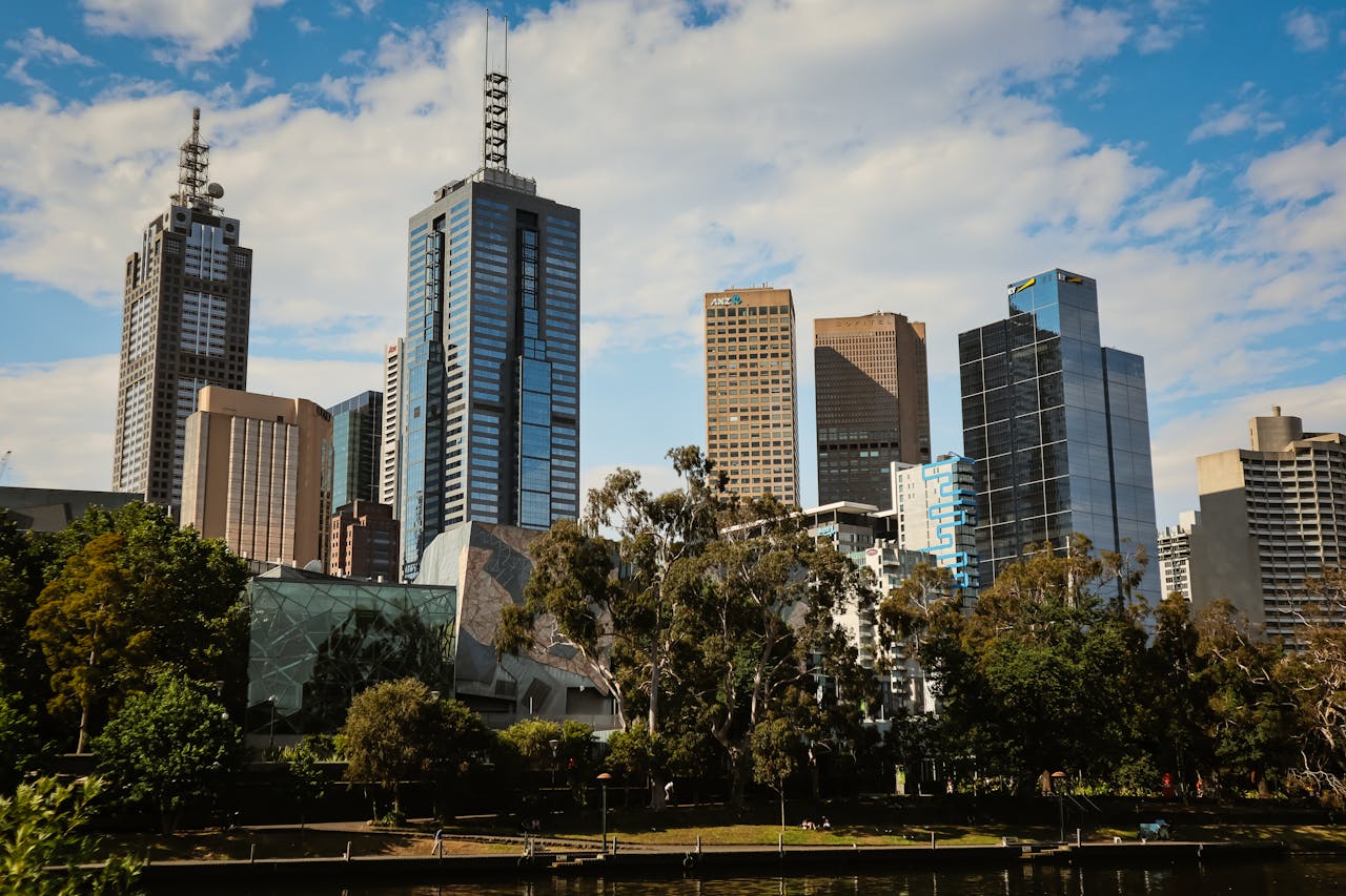 Stunning daytime view of Melbournes modern skyline with high-rise buildings and lush greenery.